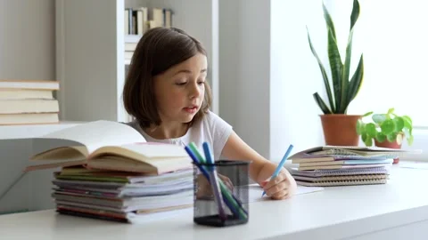 Child doing her homework at the dest at home. Education concept. Stock Footage 302288792