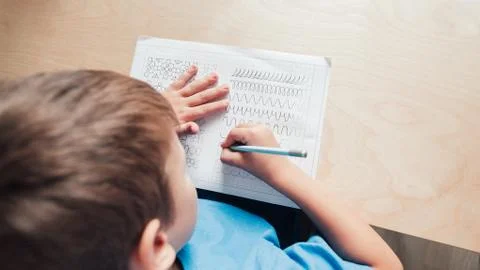 Child doing his homework. View from above 库存照片