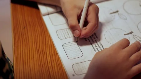 Child doing homework, drawing a line Stockbeeldmateriaal 245219969