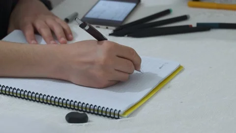 A child doing homework, drawing in a notebook, student studying, Stock Footage 130540897