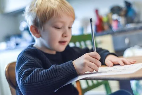 Child doing homework at the kitchen table at home during lockdown Stock Photos