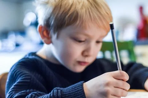 Child doing homework at the kitchen table at home during lockdown Stock Photos