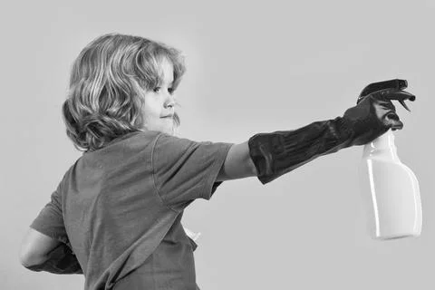 Child doing housework. Studio portrait of child use duster and gloves for Stock Photos