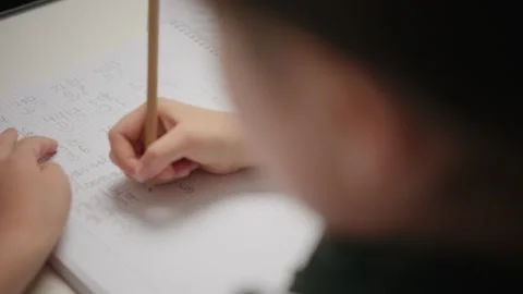 Child Doing Math Homework Writing Numbers in a Notebook Stock Footage 336618312