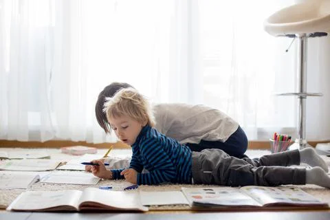 Child, doing school work on the floor at home while in quarantene Stock Photos