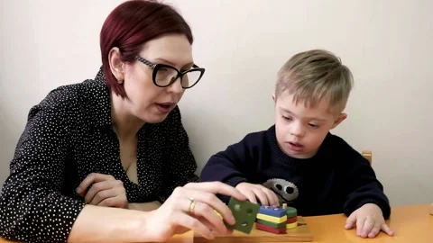 Child with Down syndrome using their imagination and playing with different Stock Footage 238861044