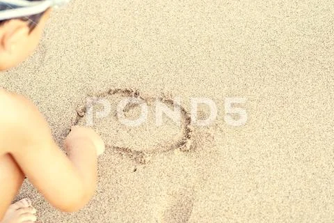 Child draw heart on sand Stock Photos