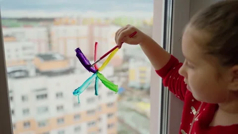 Child draw snowflake in rainbow colours on window with paints Stock Footage 166151534