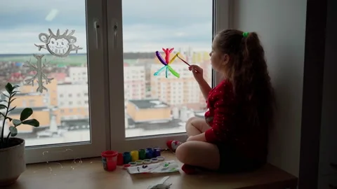 Child draw snowflake in rainbow colours on window with paints Stock Footage 166153113