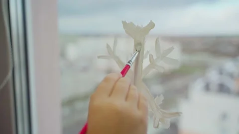 Child draw snowflake on window with paint close-up Stock Footage 166147635