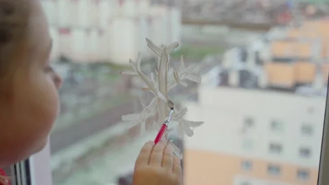 Child draw snowflake on window with paint. Real time Stock Footage 166161189