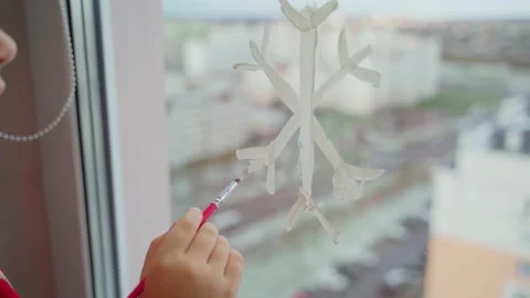 Child draw snowflake on window with paints close-up Stock Footage 166146193
