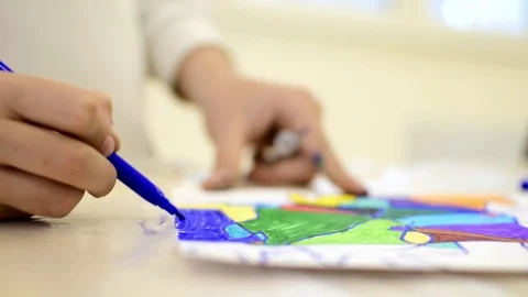 Child drawing abstract forms on a paper on vibrant colours. Vídeos de archivo 125875780