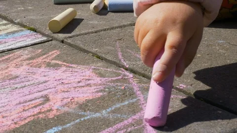 Child drawing on asphalt with chalks/crayons Stock Footage 91110539
