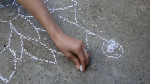 Child drawing with chalk on asphalt Stockbeeldmateriaal 86213620