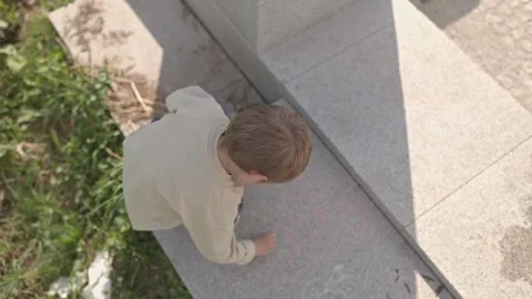 Child drawing with chalk on concrete steps Stock Footage 310794108