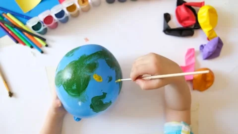 Child drawing pattern of flower and plants on the balloon. Earth day. Video stock 162148116