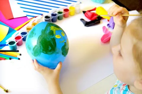 Child drawing pattern of flower and plants on the balloon. Earth day. 写真素材
