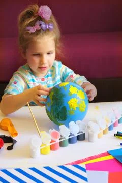Child drawing pattern of flower and plants on the balloon. Making globe. Eart Foto stock