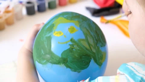 Child drawing pattern of flower  on the balloon. Earth day. Video stock 166482509