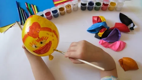 Child drawing pattern of paints fun smile on the balloon. Fun toy. Video stock 154372308