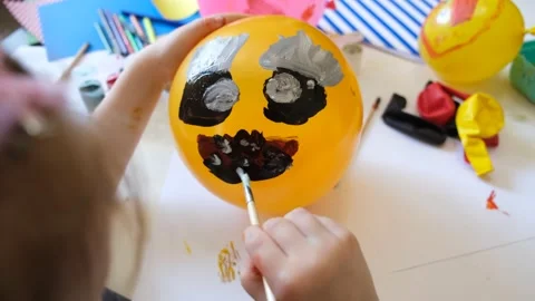 Child drawing pattern of paints fun smile on the balloon. Fun toy. Video stock 157980828