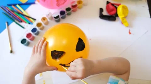Child drawing pattern of paints fun smile on the balloon. Fun toy. Stock Footage 160890040