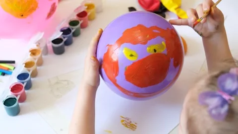 Child drawing pattern of paints fun smile on the balloon. Fun toy. Video stock 166488075