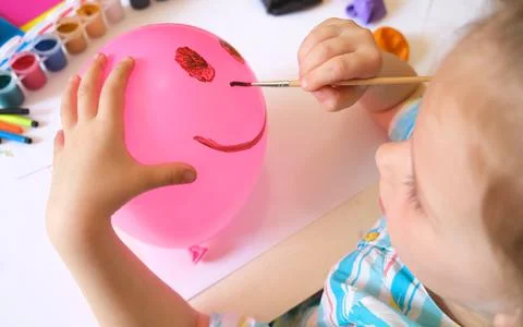 Child drawing pattern of paints fun smile on the balloon. Stock Photos