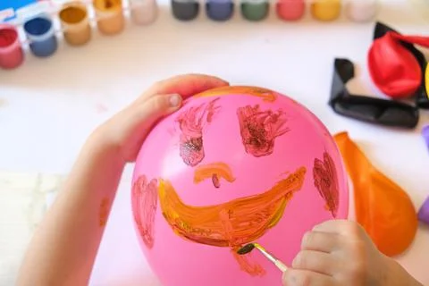 Child drawing pattern of paints fun smile on the balloon. Fun toy. Arts Stock Photos