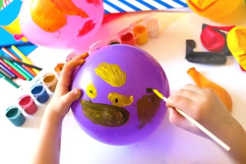 Child drawing pattern of paints fun smile on the balloon. Fun toy. Stock Photos