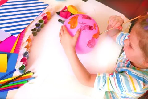 Child drawing pattern of paints fun smile on the balloon. Fun toy. Stock Photos