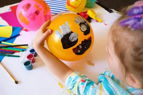 Child drawing pattern of paints fun smile on the balloon. Fun toy. Stock Photos