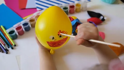 Child drawing pattern of paints smile on the balloon. Video stock 172474252