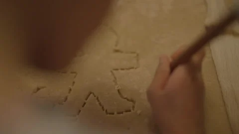 Child drawing shape in biscuit dough Stock Footage 336374536