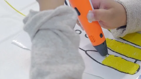 The child draws a 3d pen. Drawing with plastic threads. Stock Footage 82852570