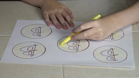 A child draws bitcoin with a felt-tip pen on paper. Stock Footage 145094821