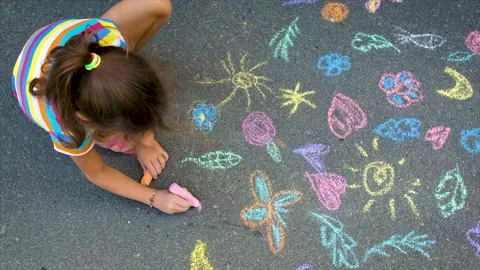 The child draws with chalk on the asphalt. Selective focus. Stock Footage 159539752
