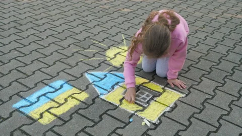 Child Draws With Chalk on Pavement Drawing of House, Sun and Ukrainian Flag.. Stock Footage 331268058