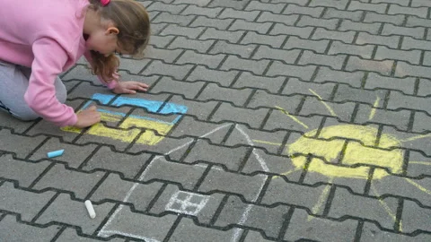 Child Draws With Chalk on Pavement Drawing of House, Sun and Ukrainian Flag.. Video stock 336028103