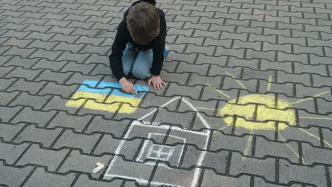 Child Draws With Chalk on Pavement Drawing of House, Sun and Ukrainian Flag.. Stock-Footage 336028267