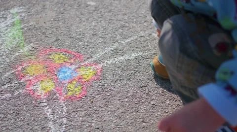 Child draws with chalk on the pavement Видео 68077763