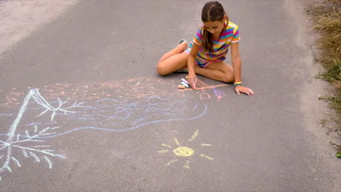 The child draws with chalk on the pavement. Selective focus. Stock Footage 202314959