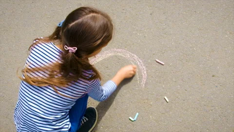 The child draws with chalk on the pavement. Selective focus. Stock Footage 220797044