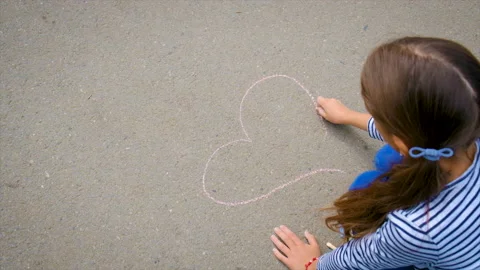 The child draws with chalk on the pavement. Selective focus. Stock Footage 221907860