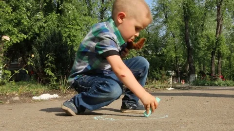 Child draws with chalk on the road. Stock Footage 98596172
