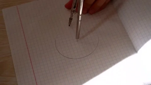 A child draws a circle on paper with a compass Stock Footage 142382933