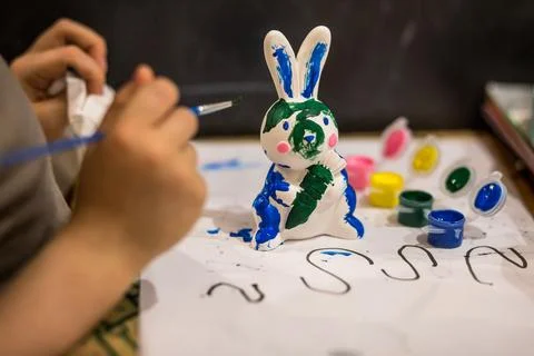A child draws an Easter bunny in different colors Stock Photos