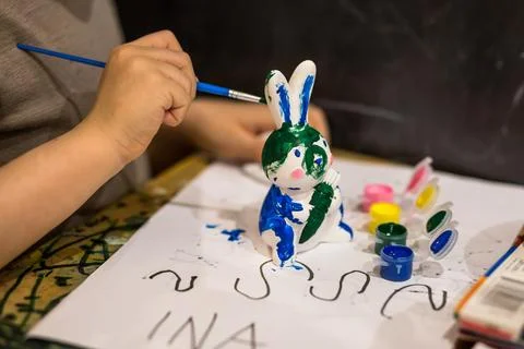 A child draws an Easter bunny in different colors Stock Photos