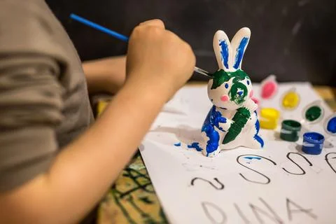 A child draws an Easter bunny in different colors Stock Photos
